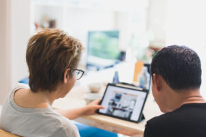 Back view of couple working on laptop at home office